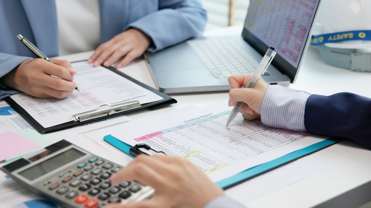 An expert reviewing financial data and cost reports in a modern audit office