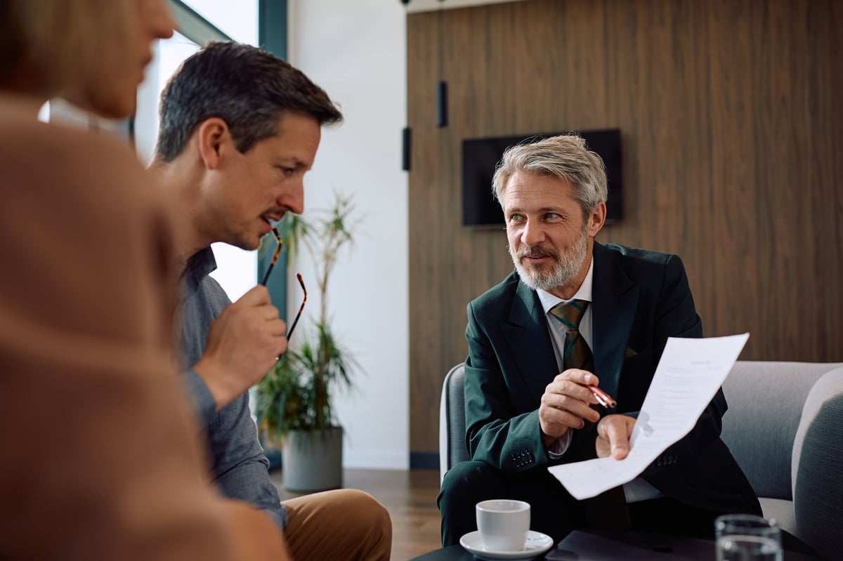 A smiling advisor reviewing financial reports with a couple during a consultation