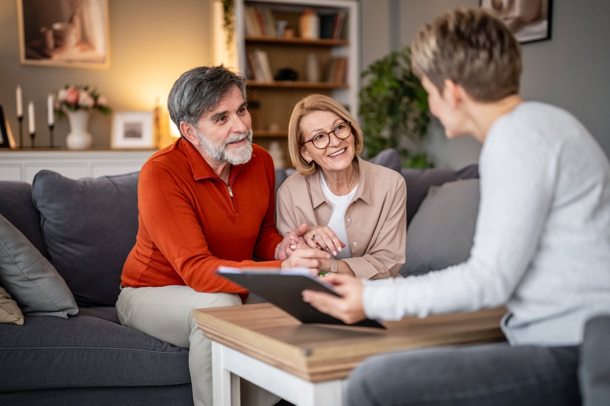A couple meeting with a trusted financial advisor in a warm, comfortable setting